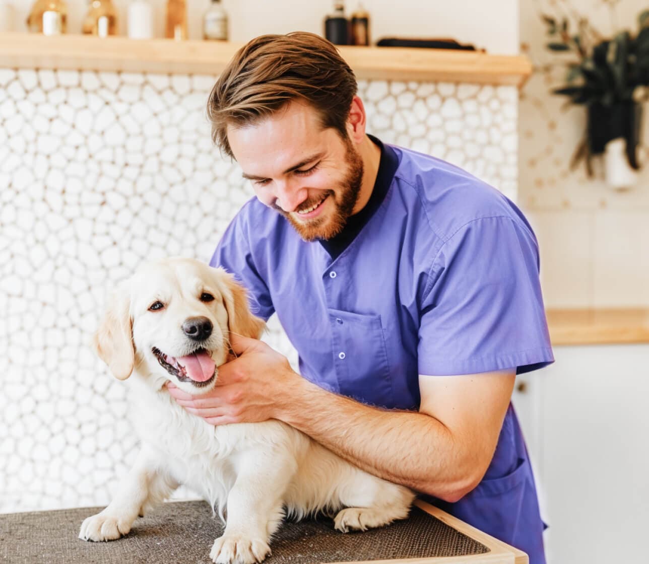 Groomer sonriendo con un cachorro de golden retriever